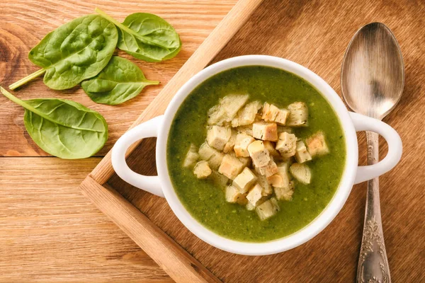 Sup sayuran hijau dengan croutons di baki kayu . — Stok Foto