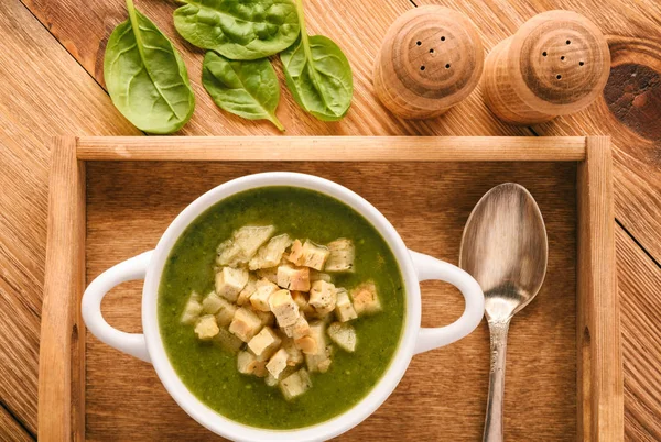 Sup sayuran hijau dengan croutons di baki kayu . — Stok Foto