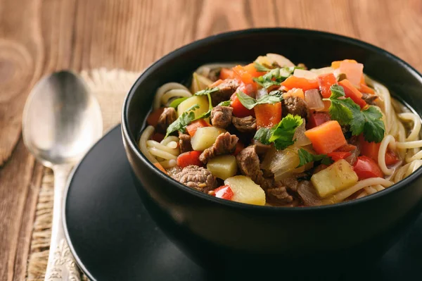 Asian traditional soup with noodles, meat and vegetables known as lagman. — Stock Image Asian traditional soup with noodles, meat and vegetables known as lagman. Royalty Free Stock Photos