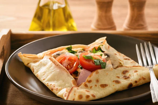 Pancakes sutffed with ham, cheese, tomatoes and mushrooms. — Stock Photo, Image