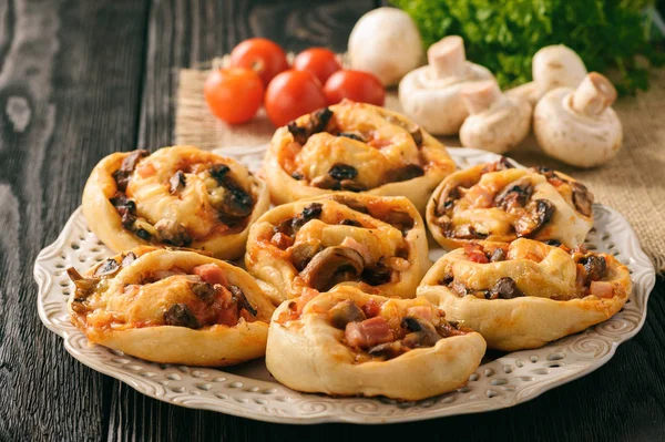 Pizzabrötchen mit Tomatensauce, Speck, Pilzen und Käse. — Stockfoto