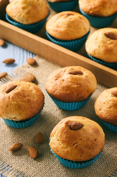 Süße Muffins mit Mandeln auf blauem Holztisch. — Stockfoto