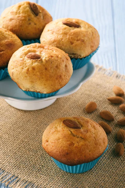 Süße Muffins mit Mandeln auf blauem Holztisch. — Stockfoto