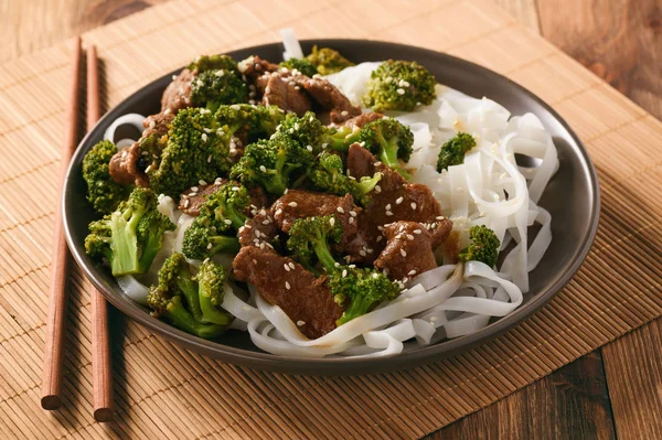 Chinese food - beef prepared with broccoli and rice noodles. — Stock Photo, Image