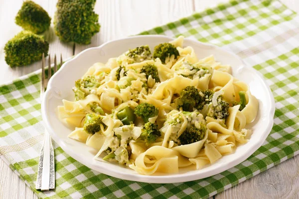Cucina vegetariana - pasta con broccoli e formaggio su fondo di legno . — Foto Stock