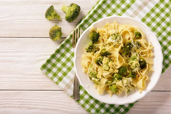 Vegetarian food - pasta with broccoli and cheese on wooden background. — Stock Photo, Image