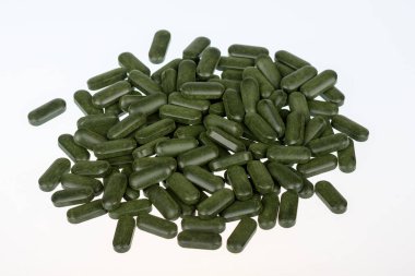 Beyaz arka plan üzerinde izole Spirulina hapları (superfood).