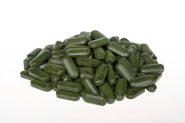 Beyaz arka plan üzerinde izole Spirulina hapları (superfood).