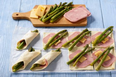 Jambon ve peynirli puf böreği kuşkonmaz pişmiş.