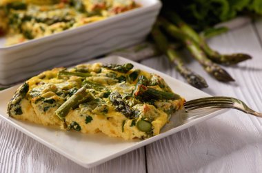 Fritata ahşap arka plan üzerinde kuşkonmaz ile.