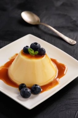 Kremalı puding yaban mersini ve karamel sos ile.