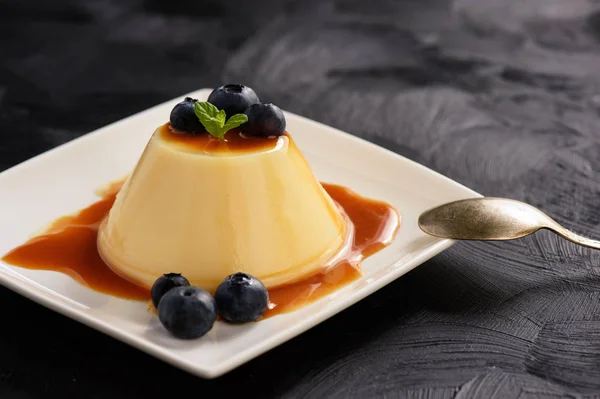 Pudim de creme com molho de caramelo e mirtilos . — Fotografia de Stock