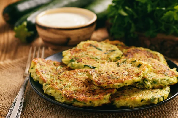 Vegetarian food - zucchini fritters on wooden background. — Stock Photo, Image