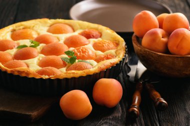 Siyah ahşap zemin üzerine kayısı ile ev yapımı cheesecake.