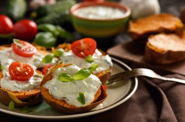 Pişmiş tatlı patates tzatziki sos ile servis.