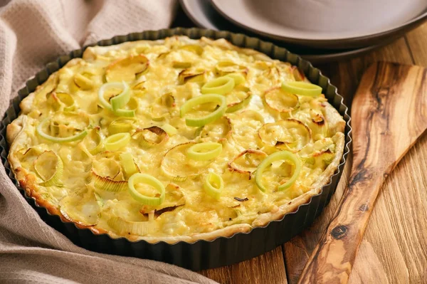 Quiche pırasa ve kahverengi zemin üzerine peynir ile.
