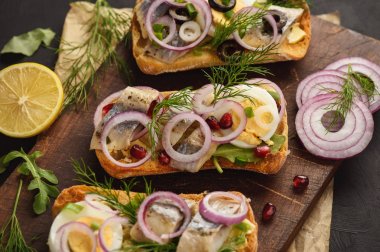 Yumurta, kırmızı soğan ve dereotu ile ringa balığı sandviç.