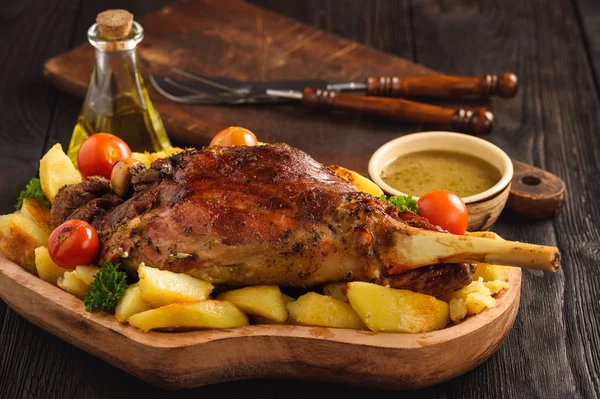Yavaş pişmiş kuzu bacak patates ve sos ile.