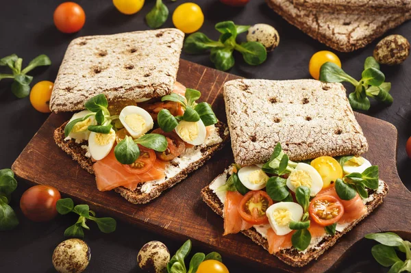 Smoked salmon sandwiches with tomatoes and eggs.