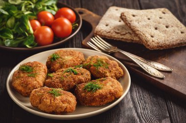 Kızarmış et Beşamel sos, domates ve ahşap zemin üzerine salata.