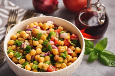 Nohut salatası yeşil biber, kırmızı soğan ve salata sosu ile.