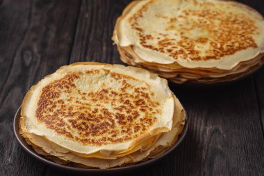 Koyu ahşap arka planda ev yapımı krep yığını..