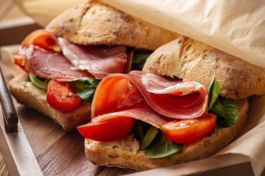 Domatesli jamon sandviçler, ahşap tepside.