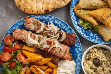 Souvlaki kızarmış patates, tzatziki sosu ve pita ekmeği ile servis edilir, Yunan mutfağı..