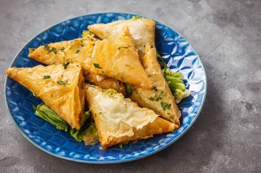 Filo hamur üçgenleri ıspanak ve feta dolgulu, geleneksel Yunan mutfağı. 