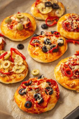 Salamlı, biberli, zeytinli ve peynirli ev yapımı mini pizza..