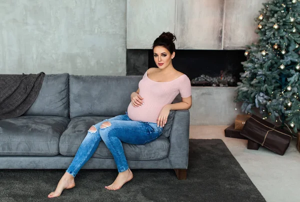 ソファにブルネットの妊娠中の女性 — ストック写真