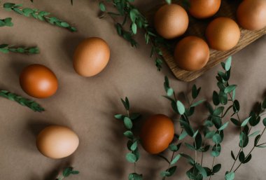 Tavuk yumurtası craft kağıt arka plan yeşil dallarda çevrili yığını 