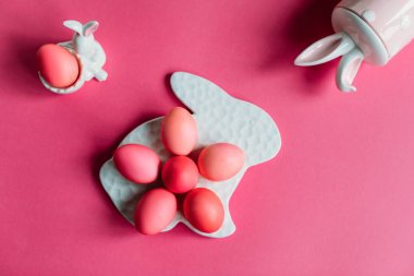 Boyalı pembe yumurta ve dekoratif rakamlar tavşan ile Paskalya kompozisyonu
