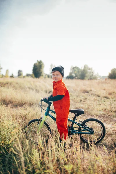 ヘルメットを被った少年が屋外で自転車に乗って — ストック写真