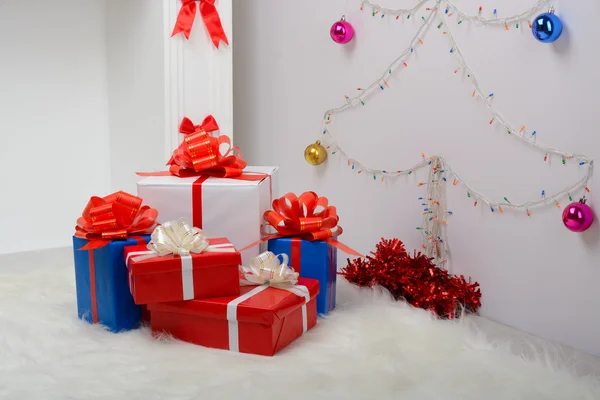 Рождественские подарки у камина и елки — стоковое фото