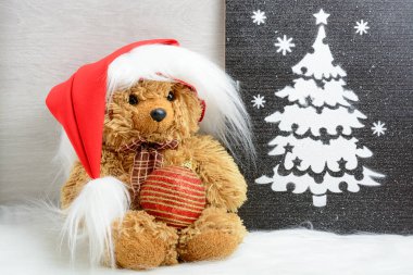 Oyuncak ayı Noel ağacı resmi yakınındaki santa şapkalı