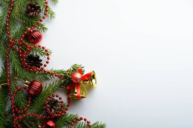 Çam dalları, kırmızı boncuklar ve çan