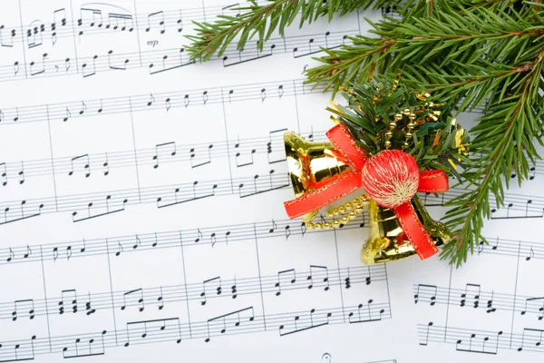 Christmas decorations lying on notes sheet — Stock Photo, Image