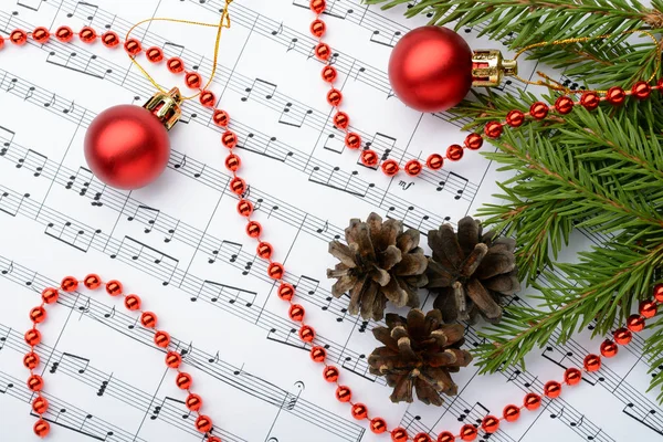 Christmas decorations lying on notes sheet — Stock Photo, Image