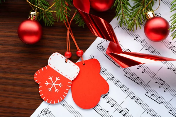 Ahşap arka plan üzerinde şekil mittens ve topları köknar dalı