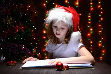 Bir kitap okuma Noel Baba şapkalı kız