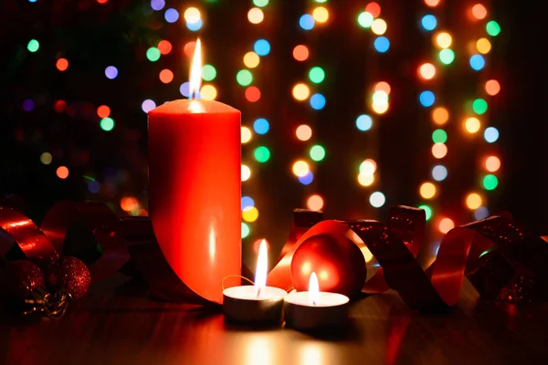 Burning candle on a table with Christmas decorations — Stock Photo, Image