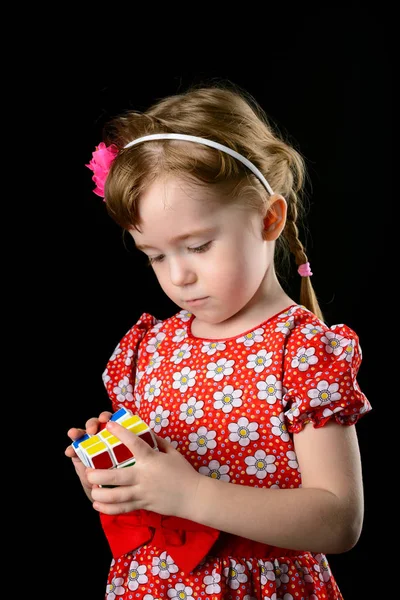 Almetyevsk City, Rusia - 7 de febrero de 2017: una niña pequeña sosteniendo un cubo de Rubik — Foto de Stock