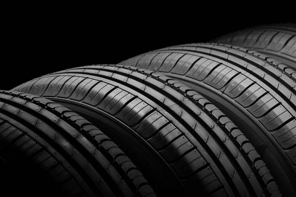 Neumáticos de coche sobre fondo negro — Foto de Stock