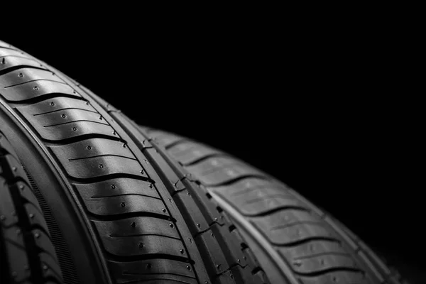 Auto pneumatiky na černém pozadí — Stock fotografie