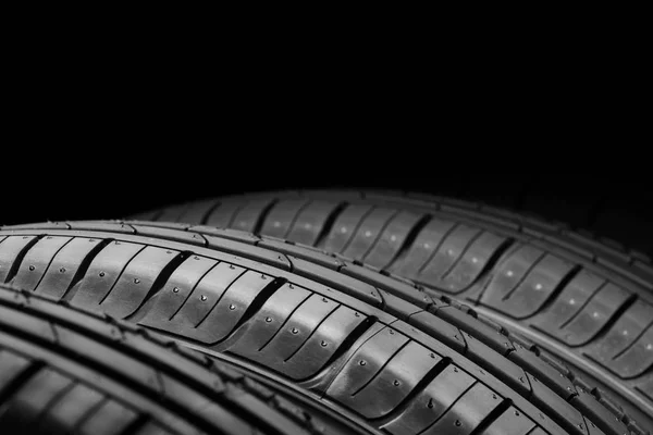 Neumáticos de coche sobre fondo negro — Foto de Stock