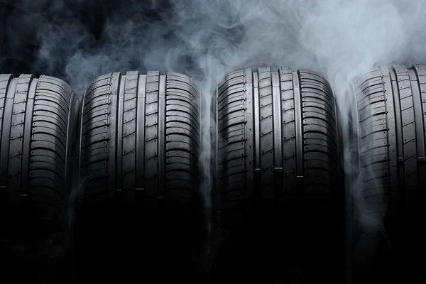 Car tires and smoke on black background