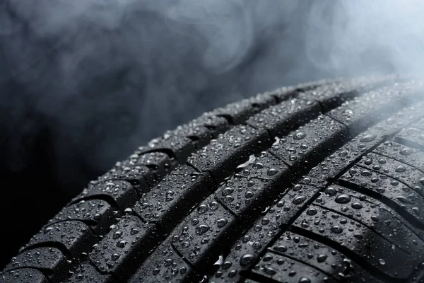 Car tire covered with water drops in the fog