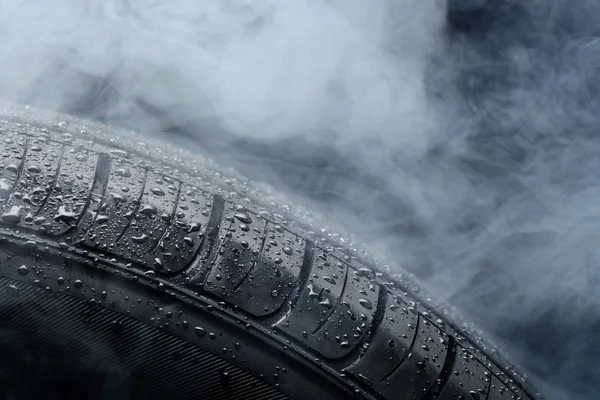 Car tire covered with water drops in the fog