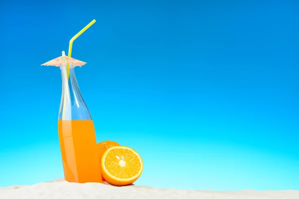 La botella de zumo de naranja y frutas en la playa —  Fotos de Stock